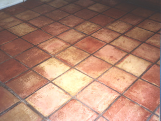 This Gilbert Arizona tile floor is covered in dirt with the grout darkened to a dark brown color before  cleaning